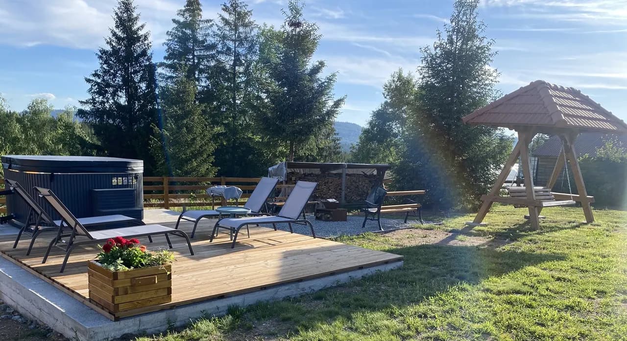 Hot tub on the deck with loungers at Cabana Măgura Mică